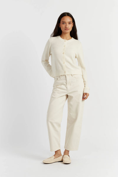 Woman wearing a cream-colored outfit on a white background