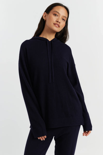 Woman wearing a navy blue hoodie on a white background