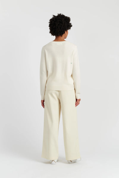 Person wearing a cream-colored outfit on a white background