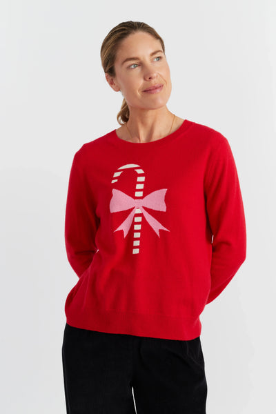 Person wearing a red sweater with a candy cane design on a white background
