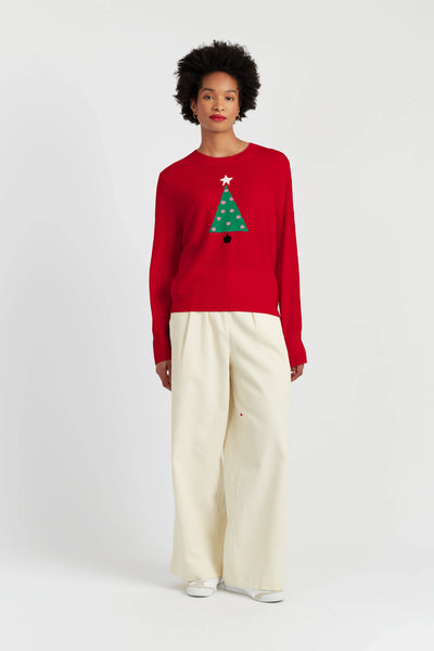 Person wearing a red sweater with a Christmas tree design on a white background