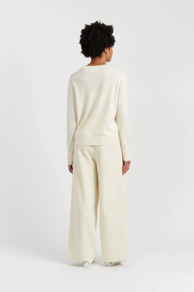 Person wearing a cream-colored outfit on a white background