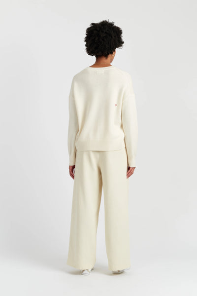 Person wearing a cream-colored outfit on a white background
