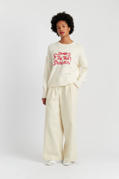 Person wearing a cream-colored outfit with a red graphic on a white background