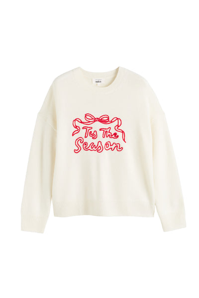 White sweater with red text 'Tis The Season' on a white background