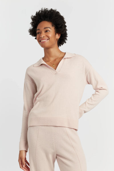 Woman wearing a light pink long-sleeve top and pants on a white background