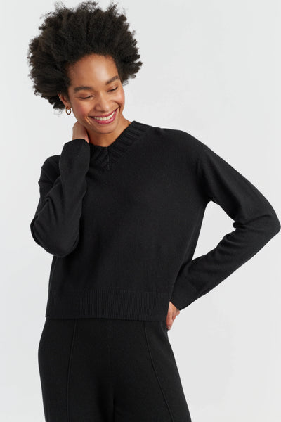 Woman wearing a black sweater against a white background