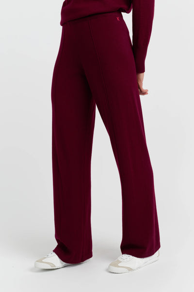 Maroon pants worn by a person on a white background