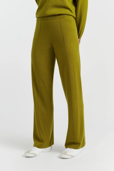 Green pants worn by a person on a white background