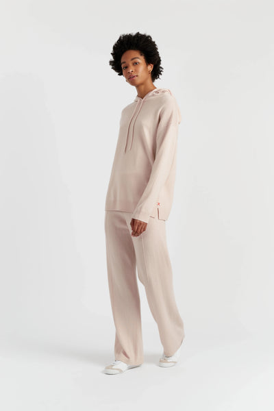 Person wearing a beige tracksuit on a white background