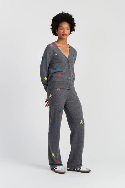 Woman wearing a gray outfit with colorful star patterns on a white background