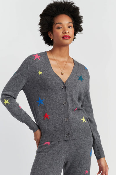 Woman wearing a gray cardigan with colorful star patterns on a light gray background