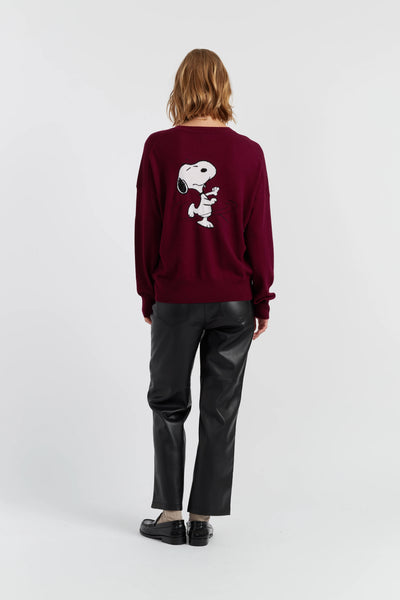 Person wearing a burgundy sweater with a white graphic on the back, standing against a white background