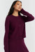 Woman wearing a purple cardigan and skirt set on a white background