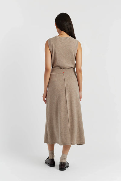 Woman wearing a beige sleeveless dress on a white background