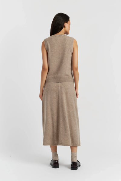 Woman wearing a beige sleeveless dress on a white background