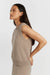 Woman wearing a beige sleeveless sweater against a white background