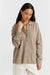Woman wearing a brown button-up shirt against a white background