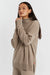 Woman wearing a beige sweater on a white background