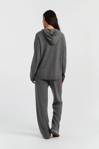 Person wearing a gray hoodie and pants on a white background