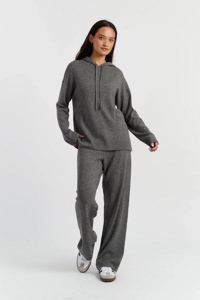 Person wearing a gray hoodie and pants on a white background