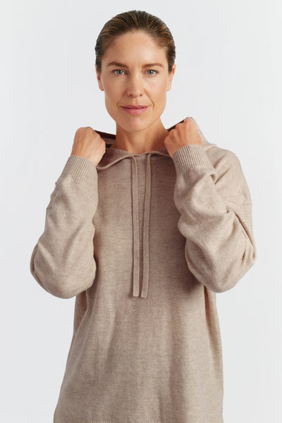 Woman wearing a beige hoodie on a white background