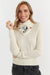 Woman wearing a cream sweater and a decorative scarf with a dog design on a white background