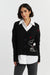 Woman wearing a black cardigan with a cartoon character design on a white background