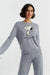 Woman wearing a gray sweatshirt with a Snoopy design on a light gray background