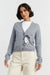 Woman wearing a gray cardigan with a cartoon character design on a light gray background