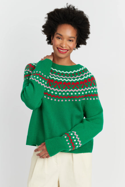 Woman wearing a green sweater with a red and white pattern on a white background