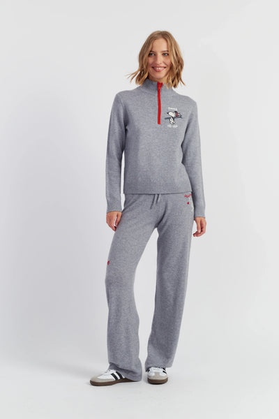 Woman wearing a gray tracksuit with a red zipper on a white background