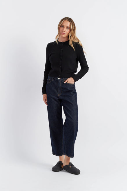 Woman wearing a black cardigan and black pants on a white background