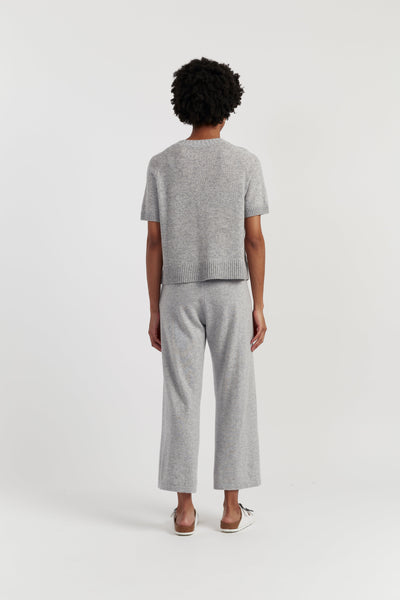 Person wearing a grey outfit on a white background