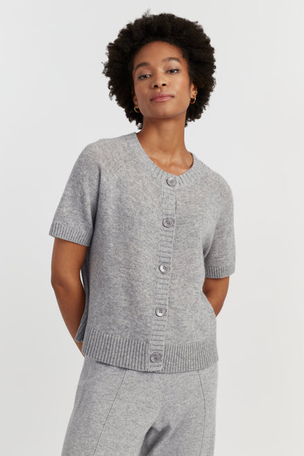 Woman wearing a grey knit cardigan on a white background