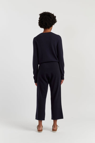 Person wearing a navy outfit on a white background