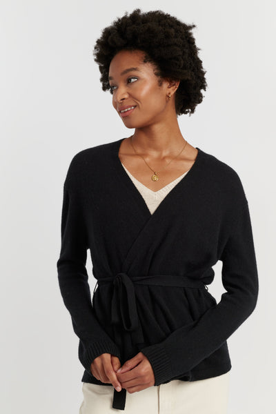 Woman wearing a black wrap sweater on a white background
