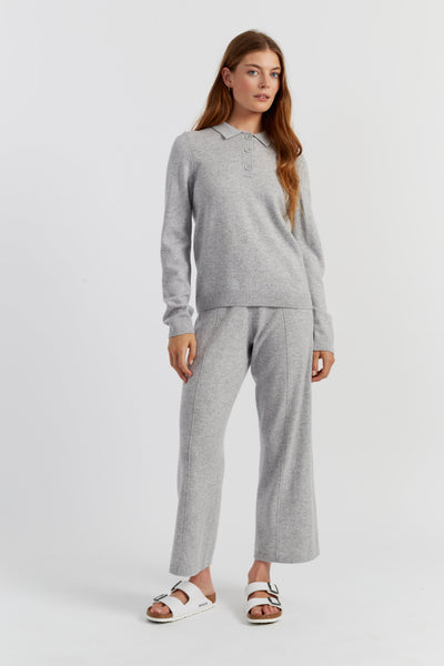 Woman wearing a grey sweater and pants set on a white background