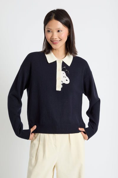 Woman wearing a navy sweater with a white collar and design on a white background