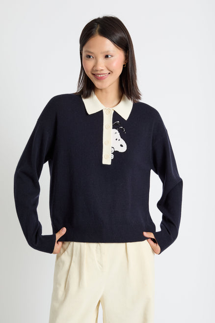 Woman wearing a navy sweater with a white collar and design on a white background