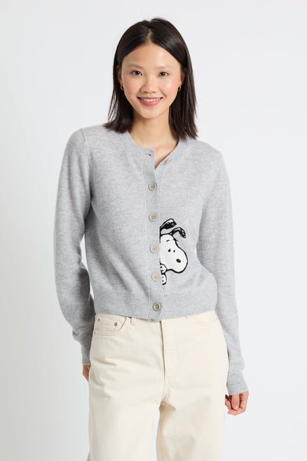 Woman wearing a grey cardigan with a cartoon character design on a white background