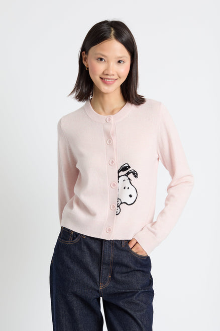 Woman wearing a light pink cardigan with a character design on a white background