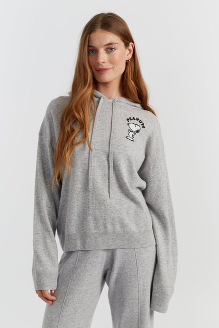 Woman wearing a grey hoodie with a logo on a white background