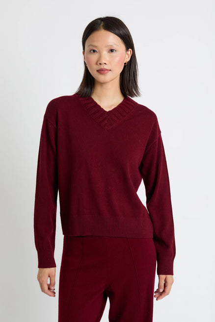 Woman wearing a burgundy sweater and pants on a white background