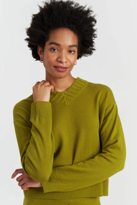 Woman wearing a green sweater on a white background