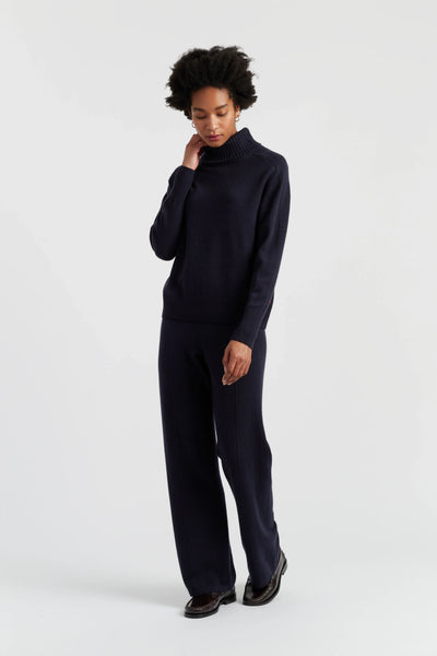 Person wearing a black turtleneck and pants on a white background