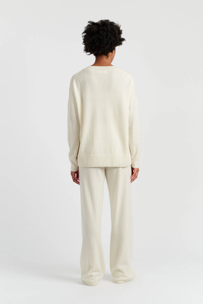 Person wearing a cream-colored outfit on a white background