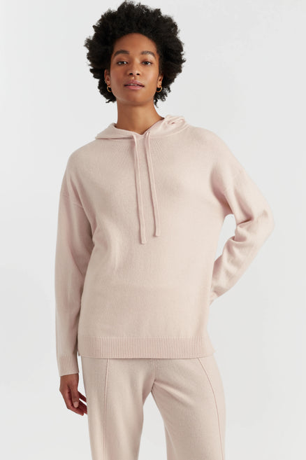 Person wearing a beige hoodie and pants on a white background