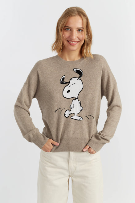 Woman wearing a beige sweater with a cartoon character on a white background