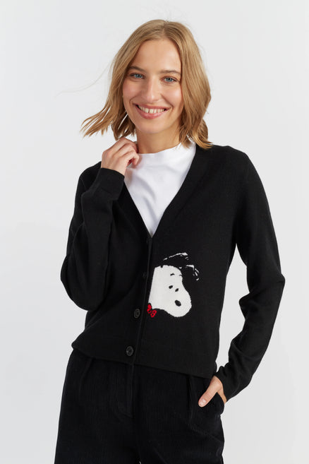 Woman wearing a black cardigan with a white graphic design on a white background